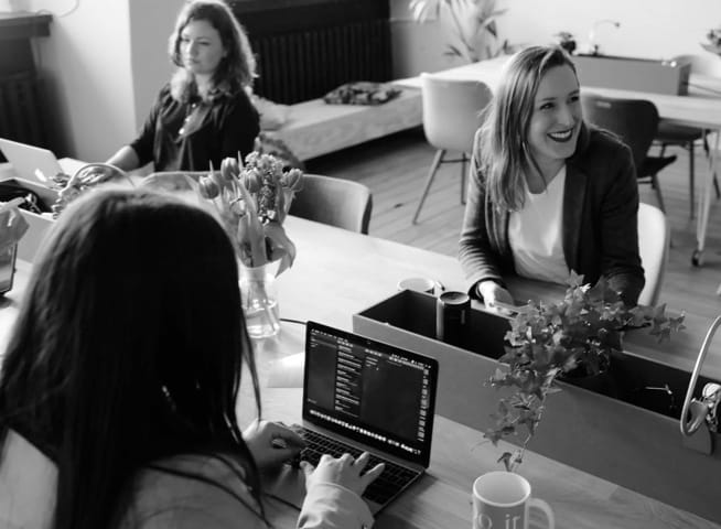 Team working together at a table with laptops and notes